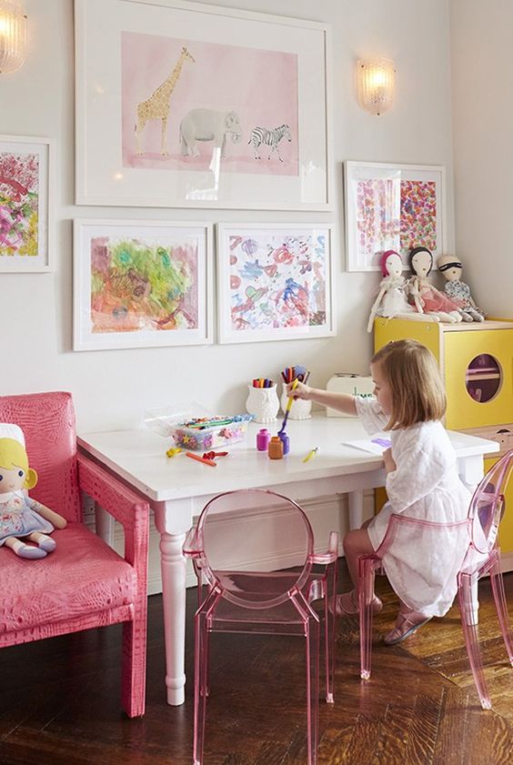 Pink and yellow play space with working table and storage.