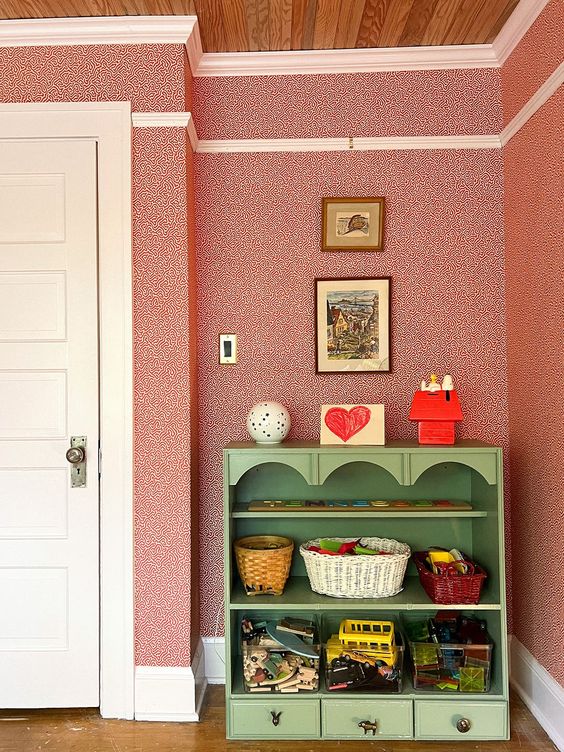 Fun, red wallpaper and green storage shelving for kids playroom ideas.